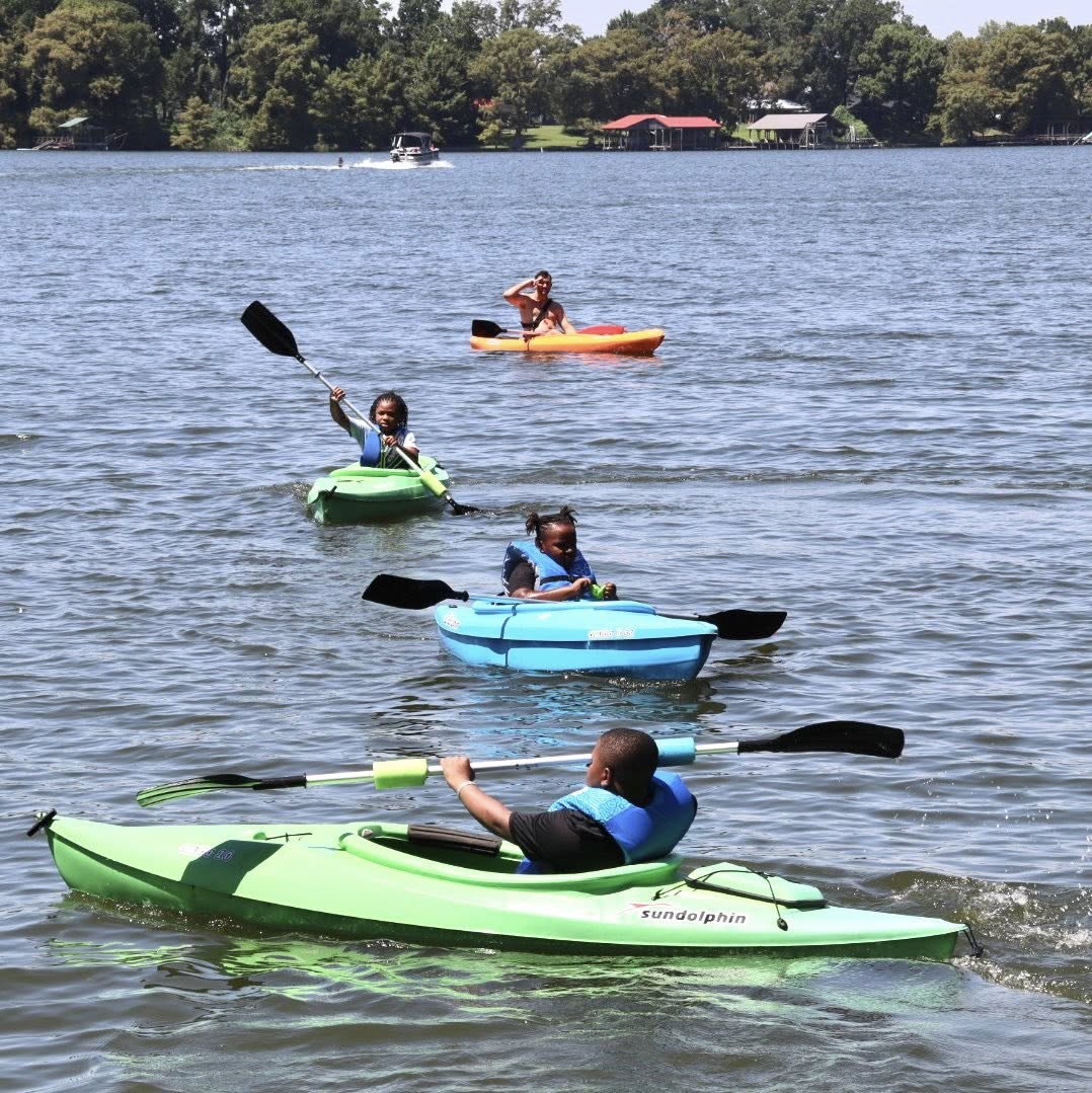 Four people kayaking in a lake.
